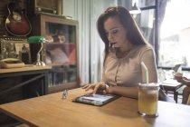 Woman using tablet in cafe — Stock Photo