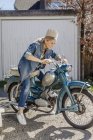 Mujer sentada en motocicleta vintage - foto de stock