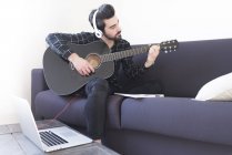 Man in headphones playing guitar — Stock Photo