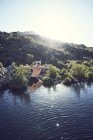 Homem pulando na água na natureza selvagem — Fotografia de Stock