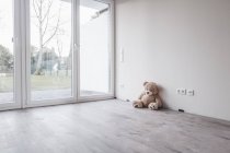 Urso de pelúcia no quarto vazio na casa nova — Fotografia de Stock