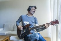 Portrait of mature man playing guitar — Stock Photo