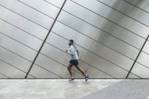 Jeune homme courant en zone urbaine — Photo de stock