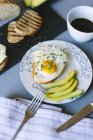 Closeup view of fried egg with avocado and toasts — Stock Photo