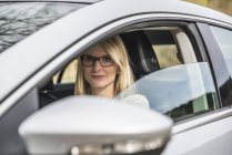 Portrait de femme confiante assise en voiture — Photo de stock