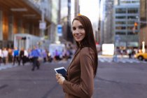 Young businesswoman with smartphone on city street,  Manhattan, New York City, US — Stock Photo