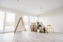 Scatole mobili e scala nella stanza vuota della nuova casa — Foto stock