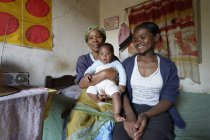 Madagascar, Fianarantsoa, Baby boy with mother and grandmother sitting in living room — Stock Photo