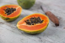 Fresh whole and halved papaya — Stock Photo
