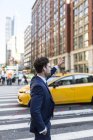 Portrait of businessman hailing taxi at street — Stock Photo
