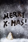 Веселий X-Mas на поверхні розливається підробленим снігом — стокове фото