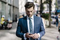 Retrato de empresário usando smartphone na rua — Fotografia de Stock