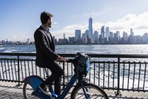 Man riding bicycle at New Jersey waterfront with view to Manhattan, USA — Stock Photo
