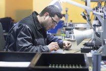 Homme travaillant dans une usine de technologie des capteurs — Photo de stock