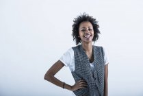 Portrait of laughing woman with hand on hip on grey background — Stock Photo