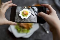 Hands taking picture of Noodles with sauce — Stock Photo
