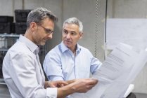 Бизнесмены обсуждают план строительства — стоковое фото