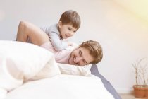 Buon padre e figlio che giocano a letto — Foto stock