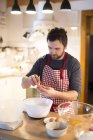 Man standing in kitchen and preparing cake dough — Stock Photo