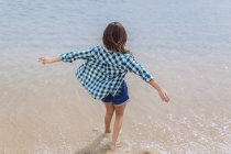Портрет женщины, стоящей на пляже с вытянутыми руками — стоковое фото