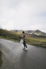 Spain, Lleida, young man on skateboard standing in rural landscape — Stock Photo