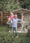 Отец носит счастливую дочь в саду — стоковое фото