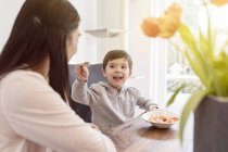 Madre e hijo desayunando juntos en la cocina - foto de stock