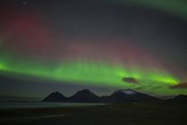 Paysage pittoresque avec aurores boréales au-dessus des montagnes qui brille la nuit, Islande — Photo de stock