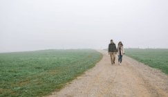 Espanha, Astúrias, Casal caminhando pelo caminho em um dia nebuloso — Fotografia de Stock