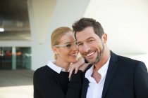Couple d'affaires souriant debout à l'extérieur — Photo de stock