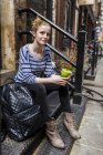 Портрет молодої жінки, що сидить на сходах з зеленою смугою — стокове фото