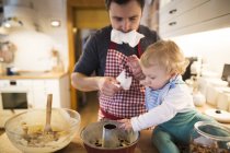 Father and baby boy baking a cake in kitchen — Stock Photo