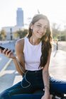 Retrato recortado de mujer joven sosteniendo teléfono inteligente - foto de stock
