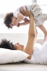 Donna incinta che gioca con il piccolo figlio a casa — Foto stock
