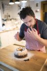 Uomo in piedi in cucina e guarnire torta anello — Foto stock