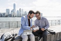 Zwei Geschäftsleute arbeiten am New Jersey Waterfront mit Blick auf Manhattan, New York City, USA — Stockfoto