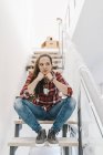 Зріла жінка, сидячи на сходах в новому будинку — стокове фото