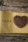 Herzförmiger Schokoladenkeks mit Schokolade mit Liebeskarte auf Holz — Stockfoto