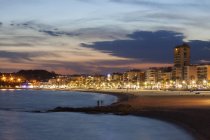 Spanien, Katalonien, Lloret de mar, Ferienort an der Costa Brava, Strand und Skyline in der Dämmerung — Stockfoto