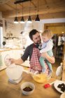 Vater und kleiner Junge backen Kuchen in Küche — Stockfoto