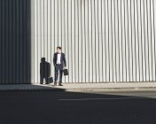 Молодий бізнесмен стоїть на тротуарі і озирається навколо — стокове фото