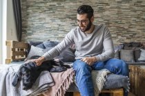 Ritratto ritagliato di uomo coccole cane nero — Foto stock