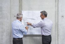 Бизнесмены обсуждают план строительства — стоковое фото