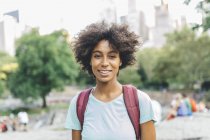 Jeune femme américaine africaine attrayante posant au parc de la ville — Photo de stock