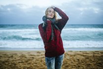Junge Frau mit geschlossenen Augen mit Meer im Hintergrund. — Stockfoto