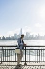 Man with cell phone standing at New Jersey waterfront with view to Manhattan, USA — Stock Photo