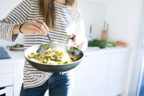 Жінка тримає сковороду з тарілкою для макаронів — стокове фото