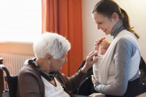 Happy old woman meeting granddaughter and great-granddaughter — Stock Photo