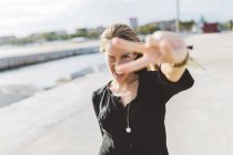 Felice giovane donna mostrando segno di vittoria all'aperto — Foto stock