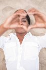 Attraente giovane donna nera mostrando il cuore dalle dita — Foto stock